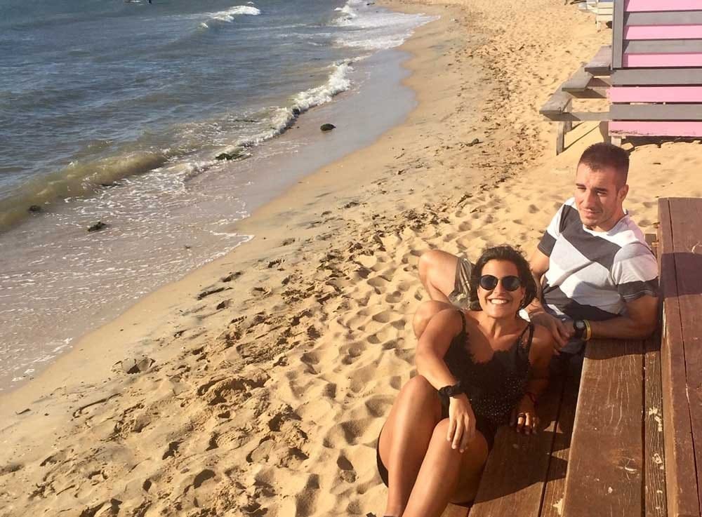 chica y chico morenos sentados en una caseta en la playa de Melbourne